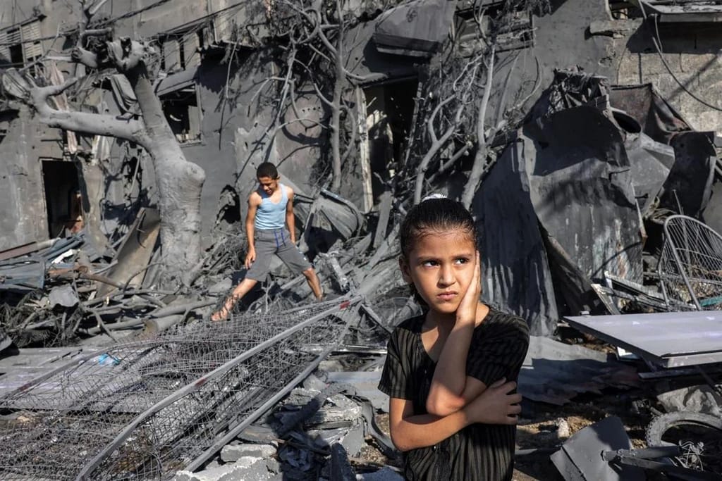 Uma rapariga olha para os escombros de um edifício atingido por bombardeamentos israelitas em Rafah, no sul da Faixa de Gaza, a 31 de outubro de 2023. Mohammed Abed/AFP/Getty Images