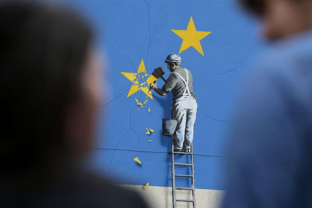 Mural pintado pelo britânico Banksy, que retrata um operário a lascar uma das estrelas da bandeira da União Europeia, em 2017