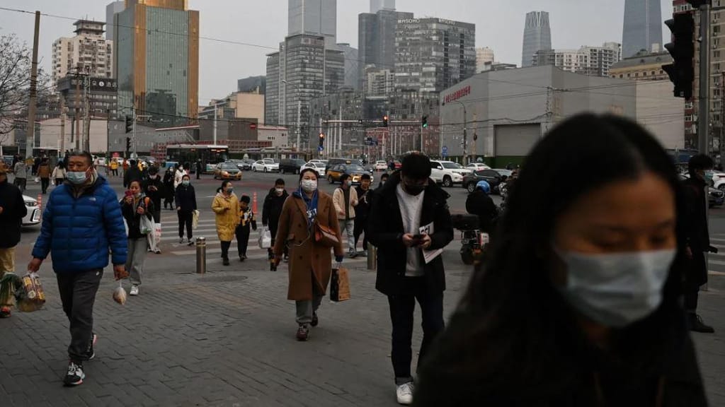 Pessoas caminham numa rua no final do dia de trabalho em Pequim. Greg Baker/AFP/Getty Images/File