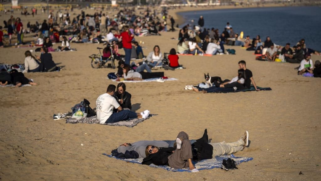 Pessoas na praia em Barcelona, em janeiro (foto: 
