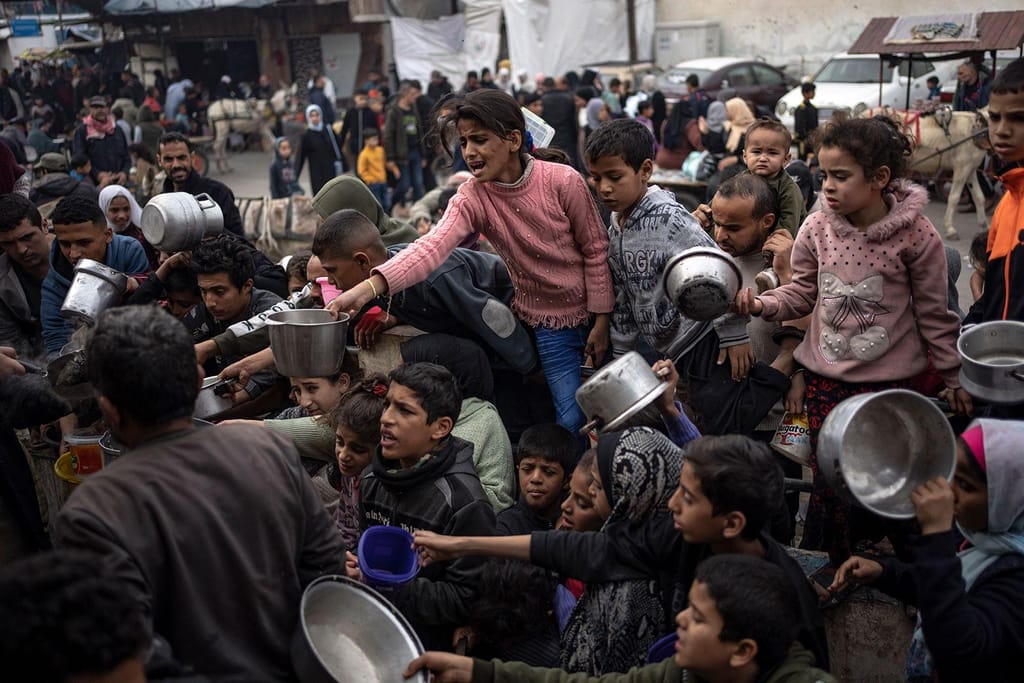 Palestinianos fazem fila para uma refeição gratuita em Rafah, Faixa de Gaza, 21 de dezembro de 2023 (Fatima Shbair/AP)