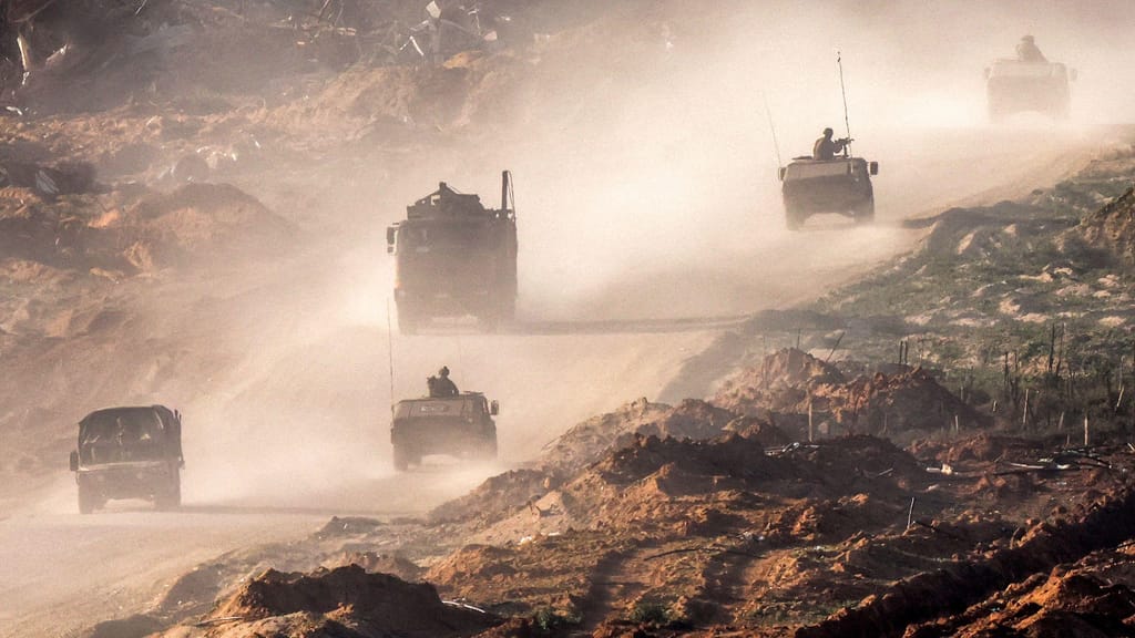 Veículos do exército israelita deslocam-se ao longo de uma estrada de terra na Faixa de Gaza, perto da fronteira com Israel, a 4 de janeiro (Getty Images)