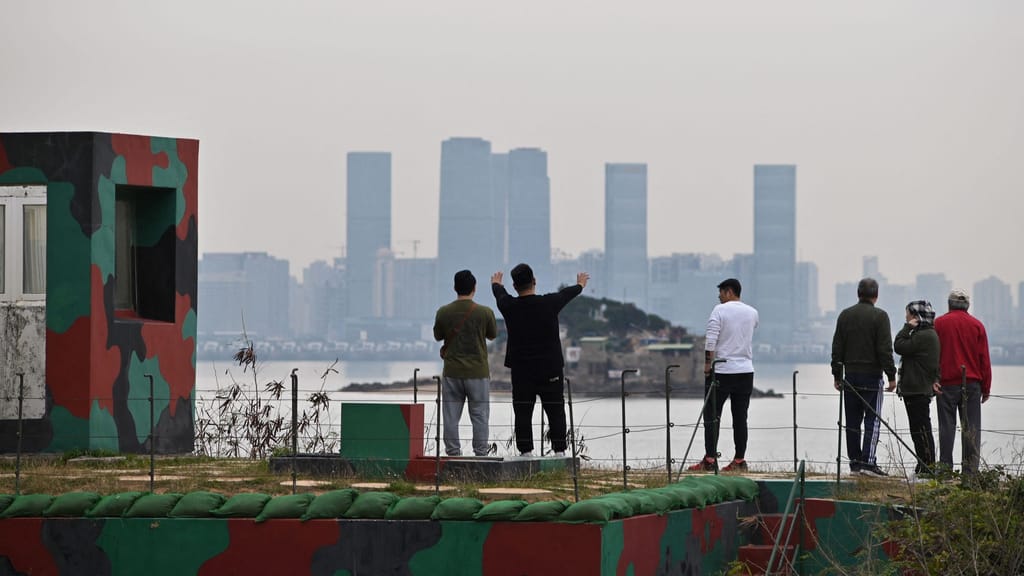 Turistas na ilha de Kinmen, em Taiwan, olham para a cidade chinesa de Xiamen do outro lado da água, a 5 de dezembro de 2023 (Sam Yeh/AFP/Getty Images)