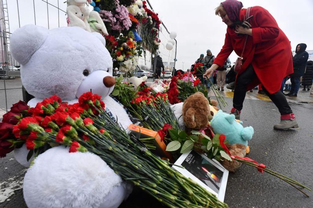 Mulher deposita flores num memorial improvisado frente à Câmara Municipal de Crocus, um dia depois de um ataque a tiro em Krasnogorsk, arredores de Moscovo, a 23 março 2024. Olga Maltseva _ AFP _ Getty Images
