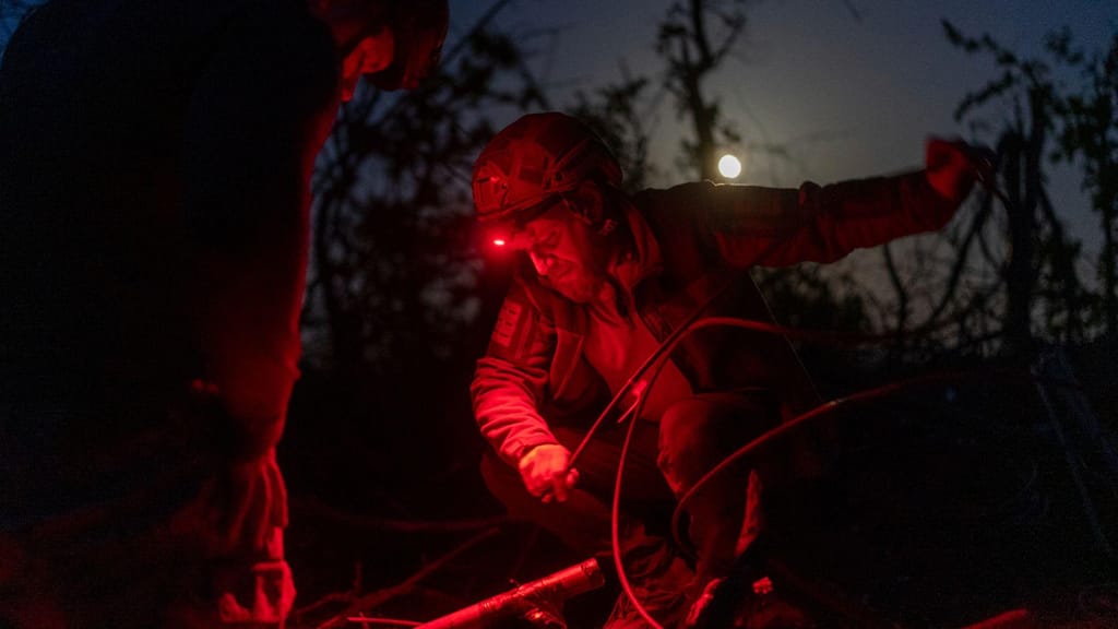 Militares ucranianos da unidade Código 9.2 ajustam uma antena na linha da frente, a poucos quilómetros de Bakhmut, 23 de abril (Alex Babenko/AP)