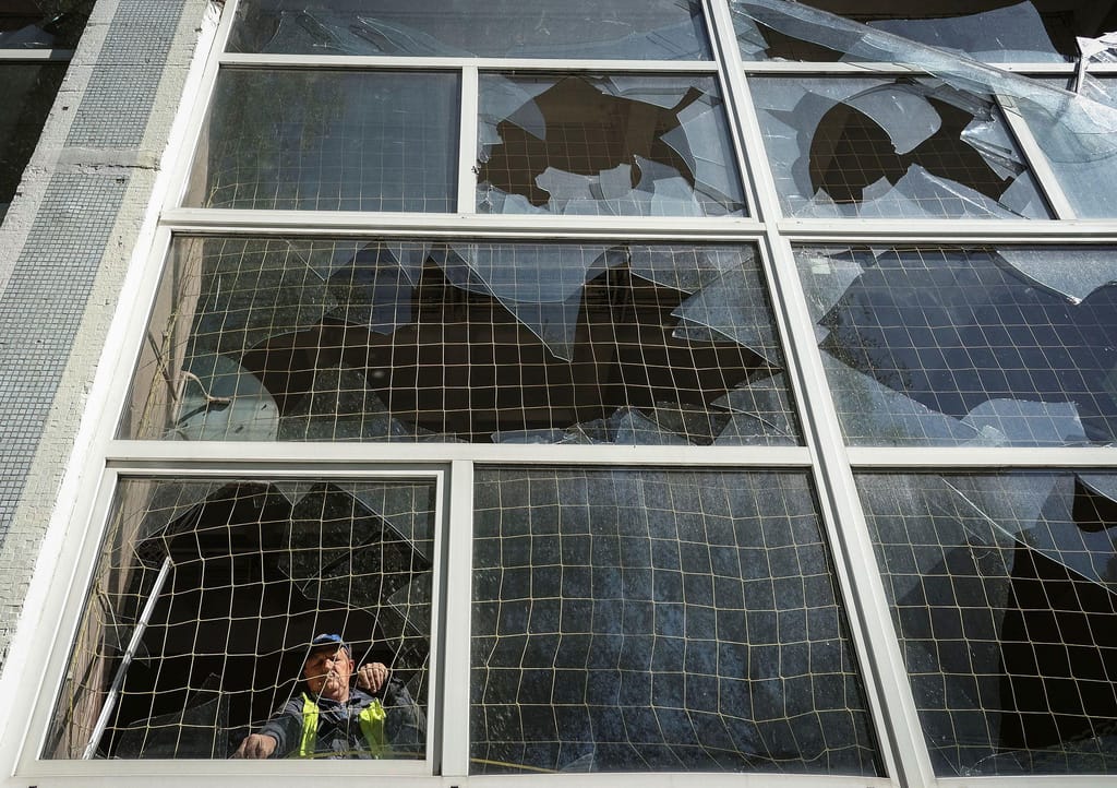 Um trabalhador retira cacos de vidro de uma janela partida numa escola danificada por um ataque de mísseis russos em Kharkiv, Ucrânia, a 8 de maio de 2024. (Sofiia Gatilova/Reuters)