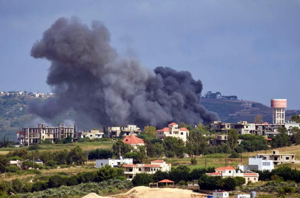 O fumo emana do local de um ataque aéreo israelita à aldeia libanesa de Jebbain, a 25 de maio de 2024, no meio de confrontos transfronteiriços entre tropas israelitas e combatentes do Hezbollah. Stringer/AFP/Getty Images